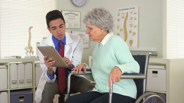 Mexican doctor talking to old woman with tablet