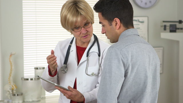 Doctor talking to patient with tablet