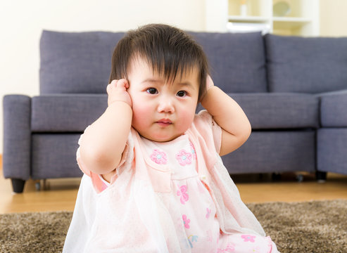 Asian baby girl cover ear