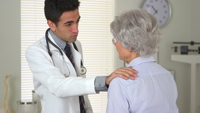 Mexican doctor talking to senior patient