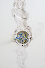 Undone AC power socket in wall. Repairs in the apartment.