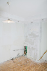 Room renovation. Gypsum plasterboard with undone socket bulbs.