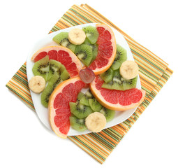 Assortment of sliced fruits on plate, isolated on white
