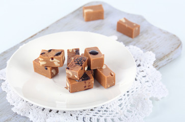 Many toffee on plate on cutting board isolated on white