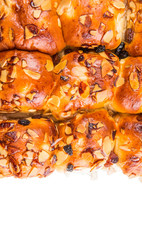 Homemade sweet bun with almond and raisins on a white plate