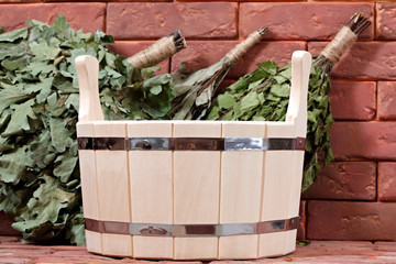 Naklejka premium Bucket for a bath on a brick surface. Equipment for saunas