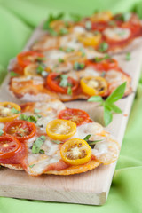 Mini pizzas with mozzarella, cherry tomatoes and basil