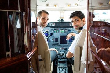 Pilots In Corporate Plane Cockpit - obrazy, fototapety, plakaty
