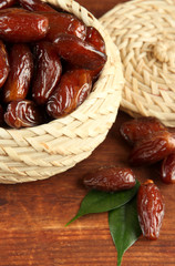 Dried dates in basket on wooden background