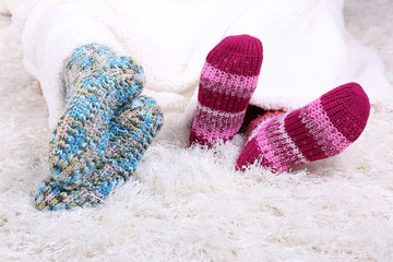 Legs in colorful socks on white carpet background
