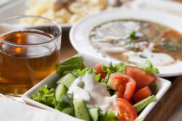 Lunch set of salad with drink and out of focus soup