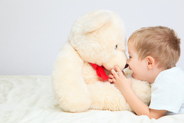 Portrait of little boy with teddy bear at home