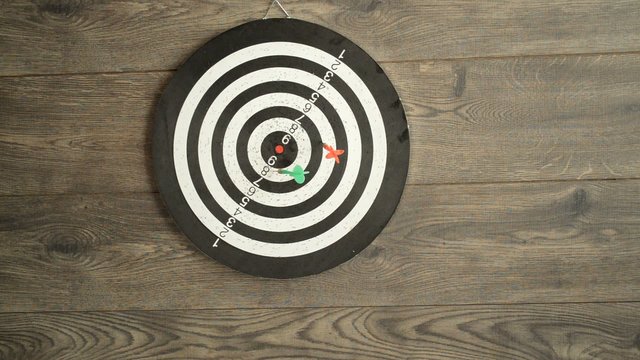 hand throwing darts at a target
