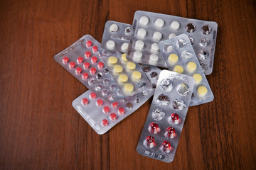 pills in packages on a wooden background