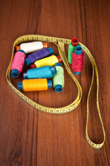 colorful spools of thread on a wooden background