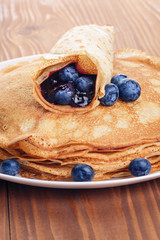 homemade blinis or crepes with blueberries and jam