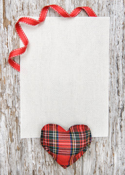 Valentine card with textile heart on old wood