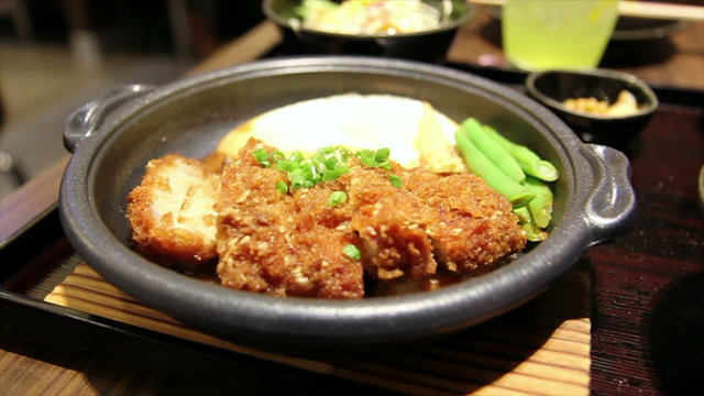 japanese food fry pork tongkatsu with egg on hot metal plate