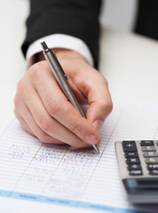 Naklejka premium close up of businessman with papers and calculator