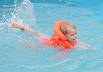 Fototapeta na wymiar Little child in the life jacket floating. Insurance concept.