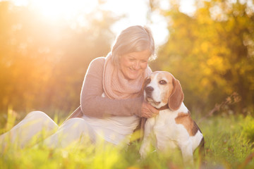 Active senior woman hugs dog
