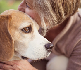 Active senior woman hugs dog