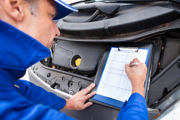 Mechanic Maintaining Car Records