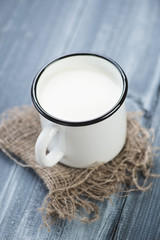 Cup of milk on a wooden table, vertical shot