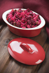 Beetroot salad with oil and vinegar on a wooden surface