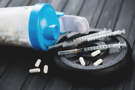Shaker with tablets, syringes and weight disk, close-up