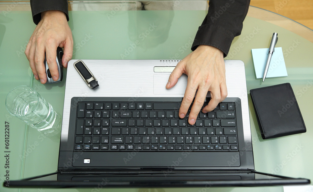 Wall mural young businessman working in office, sitting at desk with lapto