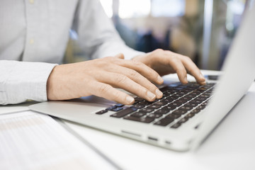 Man Typing on a keyboard laptop in an office, e-mail, message