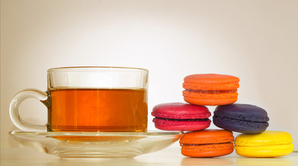 Cup of tea with heap of colorful cookies