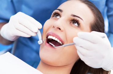 Woman having teeth examined at dentists