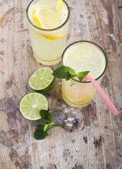 Fresh limes and lemonade on wooden background