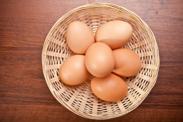 Chicken eggs in a wicker basket on the table