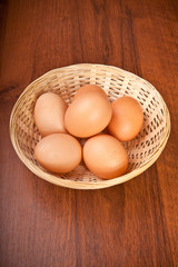 Chicken eggs in a wicker basket on the table