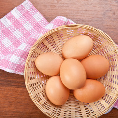 Chicken eggs in a wicker basket on the table