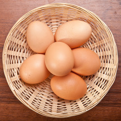 Chicken eggs in a wicker basket on the table