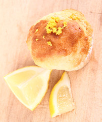 Lemon muffin and a piece of lemon on a wooden background