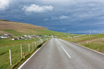 Road running through green fields of Faroe Islands