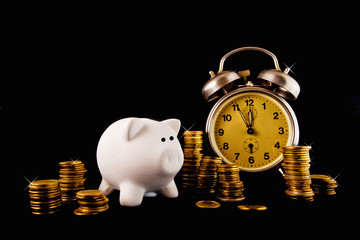 Golden coin stack, piggy coin bank and vintage clock on dark bac