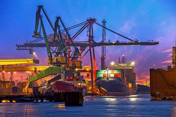 The unloading of a container ship at a large harbor terminal.