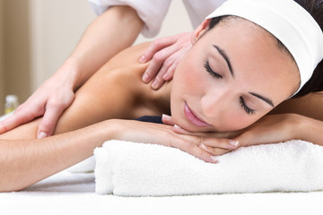 Woman enjoying shoulder massage at beauty spa