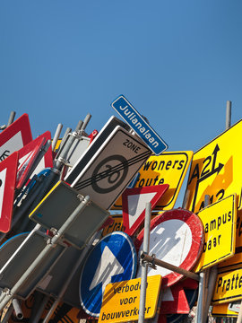 Different Dutch traffic signs against a blue sky