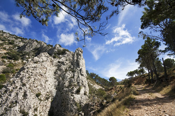 Fototapeta premium Country road in the hills with mountain rock in Alicante, Spain