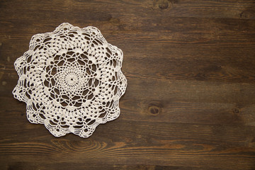 Crochet doily overdark  wood - obrazy, fototapety, plakaty