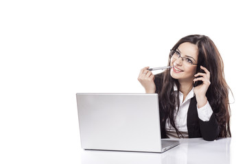 smiling business woman talking on her phone next to a laptop