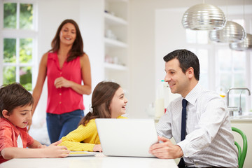 Family Using Digital Devices At Breakfast Table