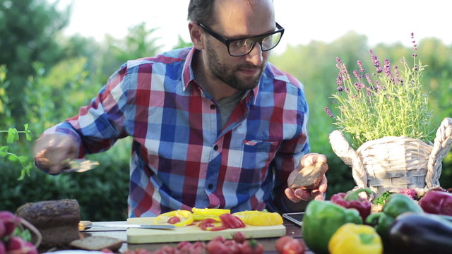 man preparing sandwich by the table in the garden